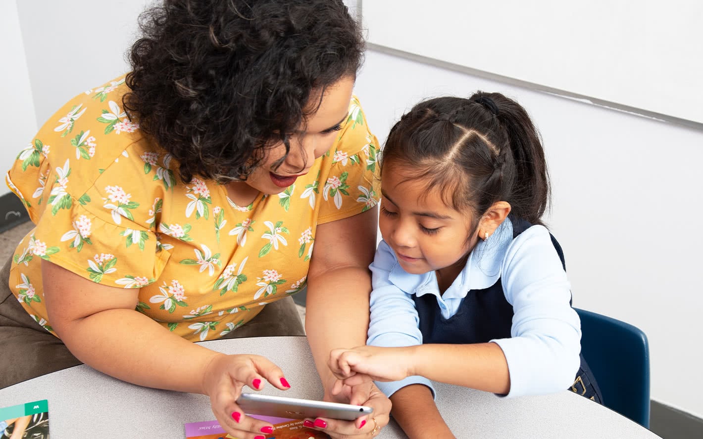 Teacher looking at tablet with student