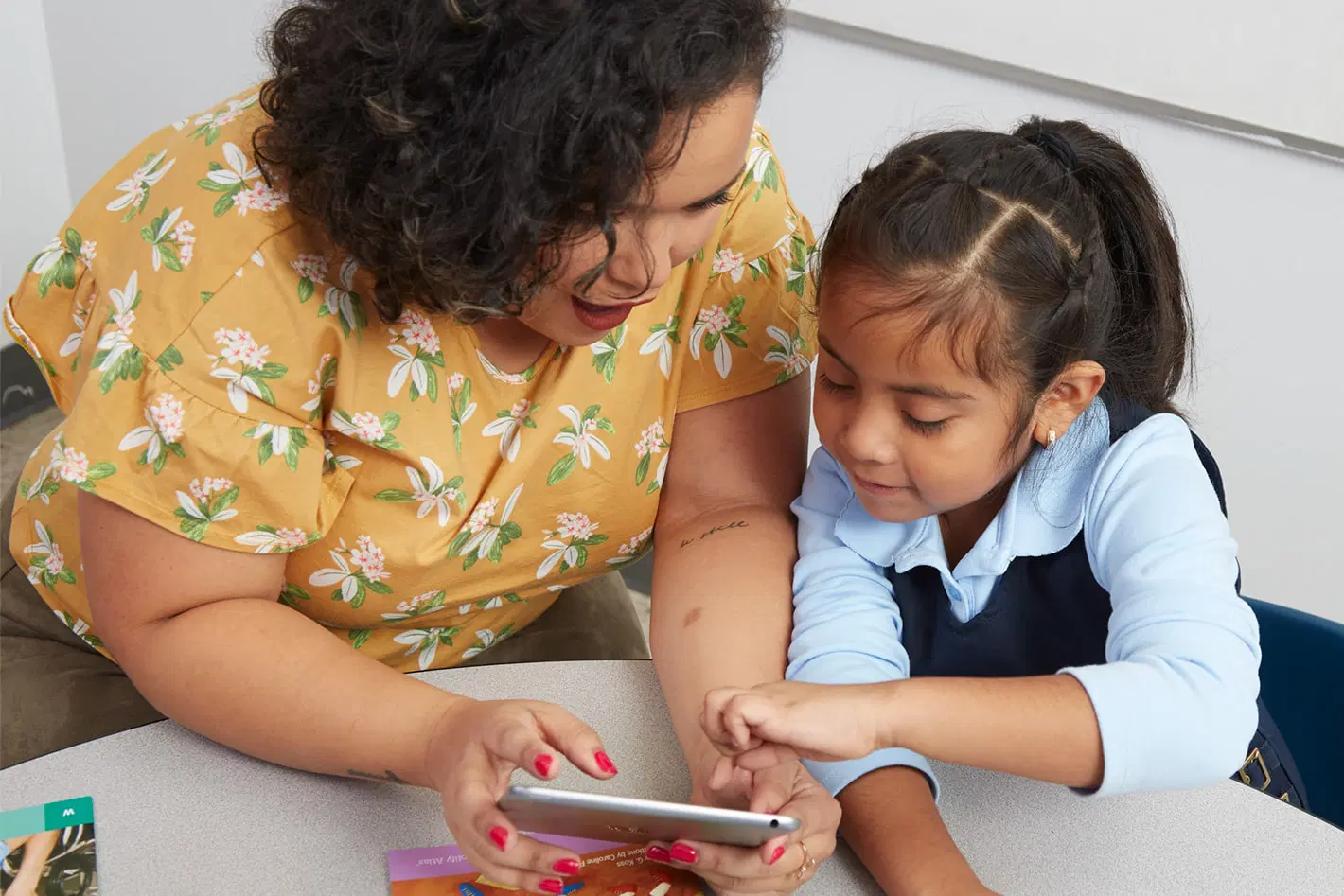 Teacher looking at tablet with student