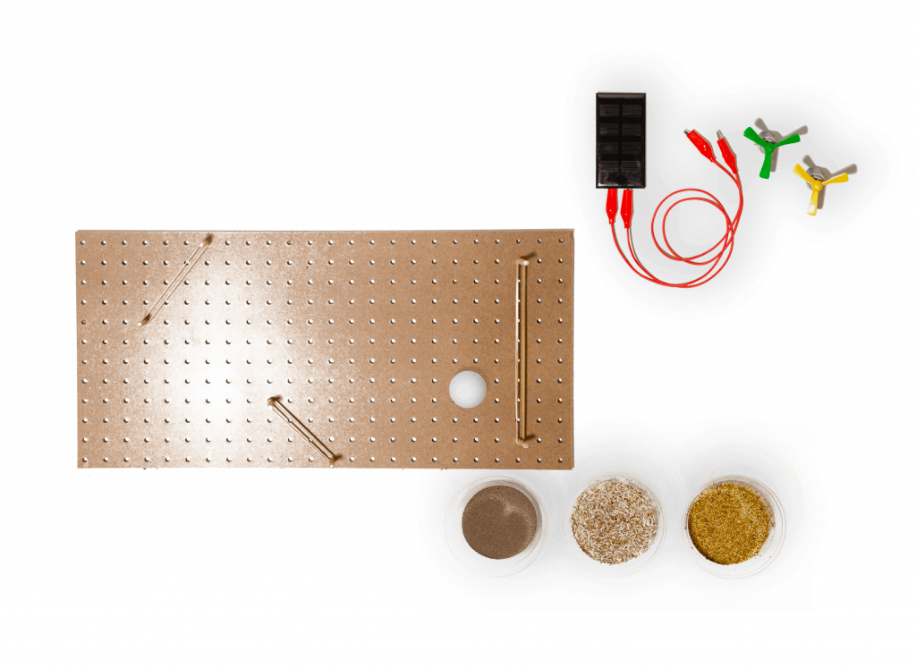 A perforated rectangular board, three small containers with different powders, a black battery holder with red wires, and three colored alligator clips are arranged on a white background.