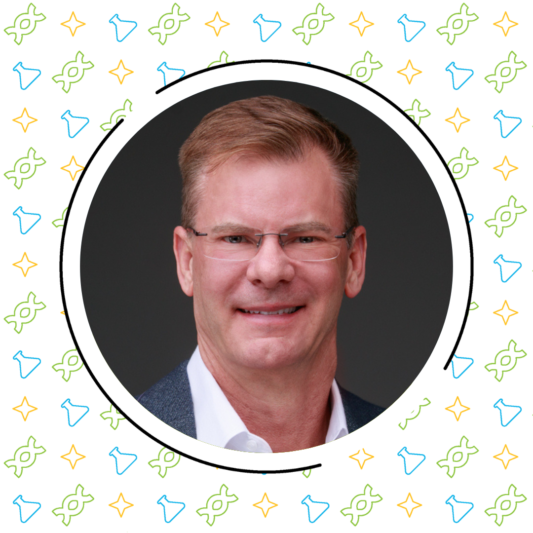 A middle-aged man with short brown hair and glasses, smiling in a professional portrait, surrounded by a circular frame with a colorful pattern of integrating science & literacy.