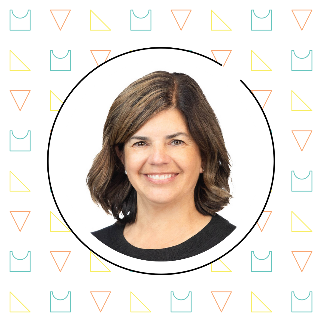 Portrait of a smiling math teacher with shoulder-length brown hair, set against a white background framed by a circular border with a pattern of colorful geometric shapes.