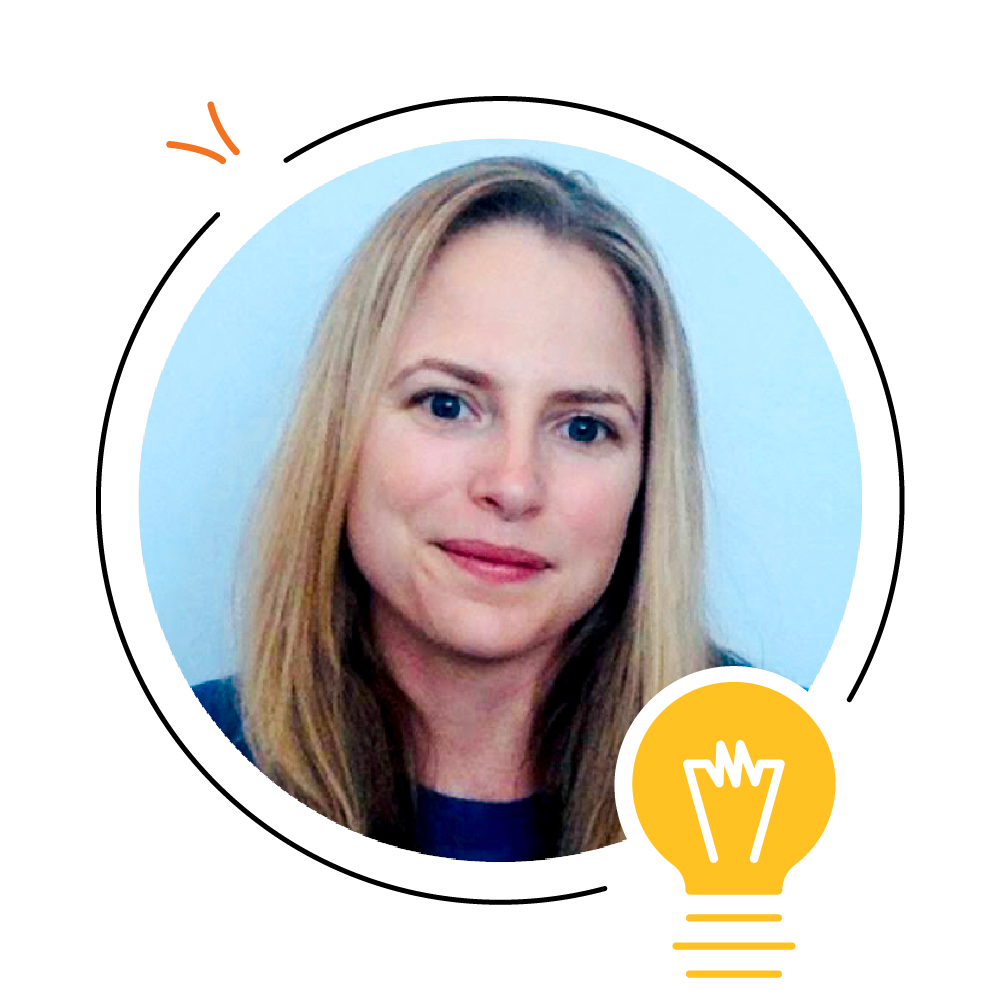 Una mujer con cabello rubio de longitud media, vestida con una blusa azul, sonríe levemente en un marco circular con una bombilla y una flecha superpuestas inspiradas en la cuerda de Scarborough.