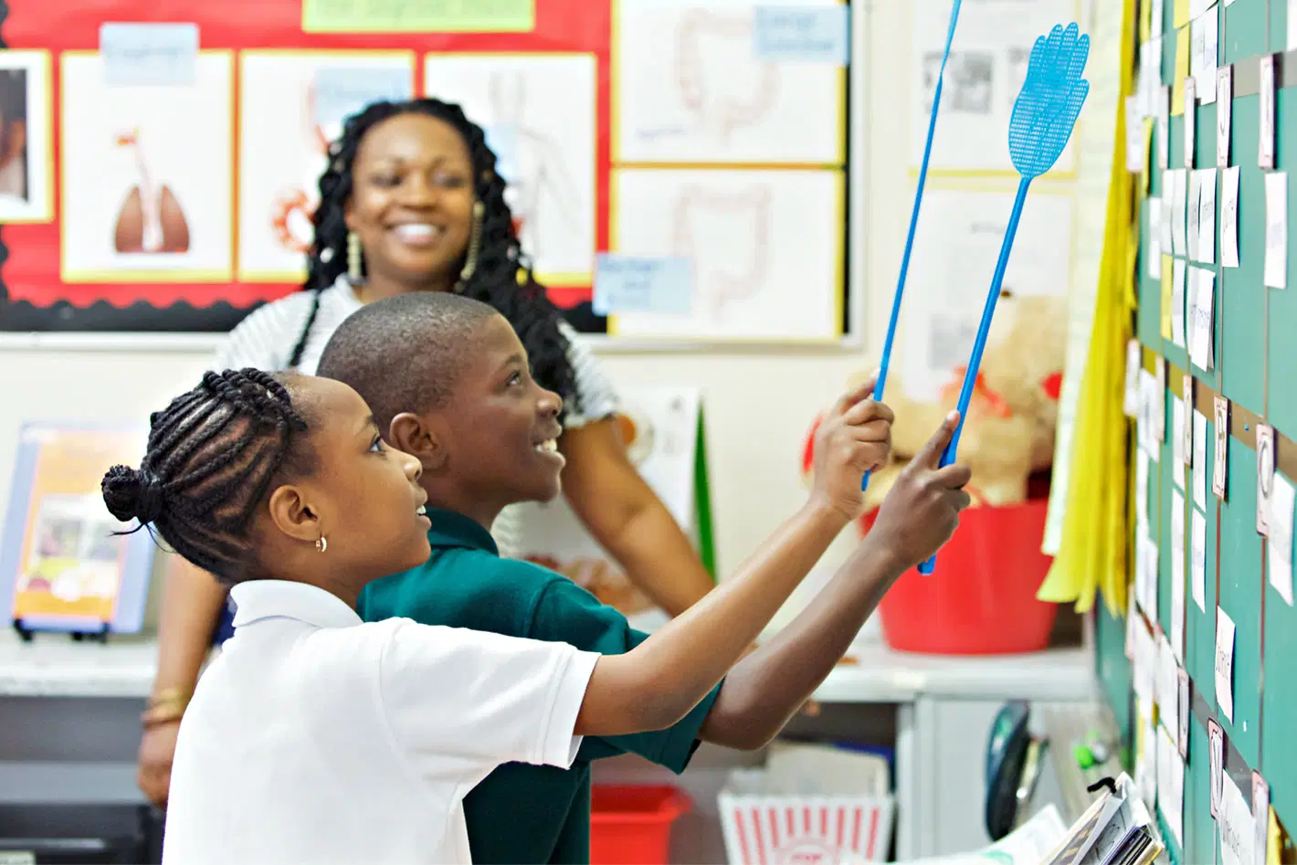 students touching word wall with teacher
