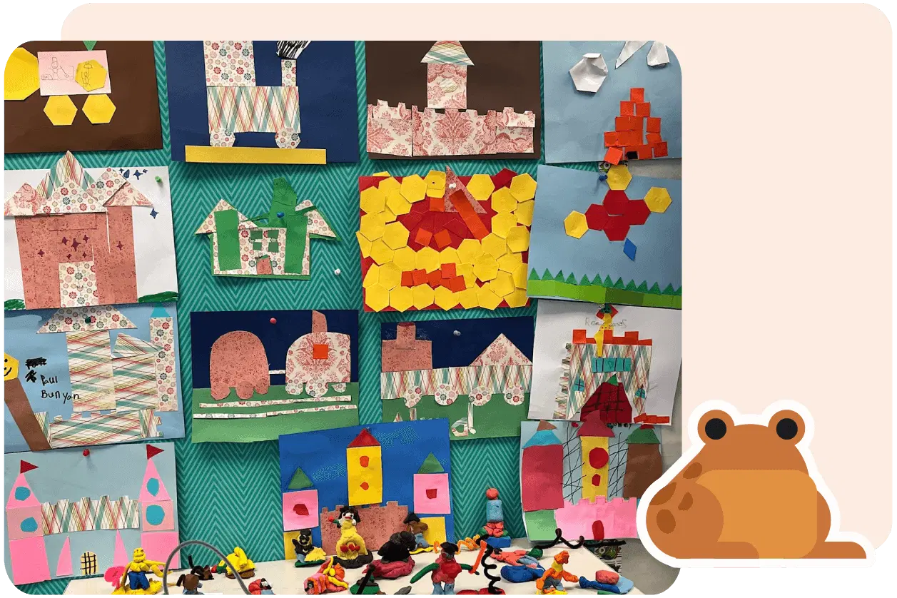 A display board with colorful, geometric art projects. Below, small toy animals are arranged. A cartoon frog is positioned in the corner of the image.