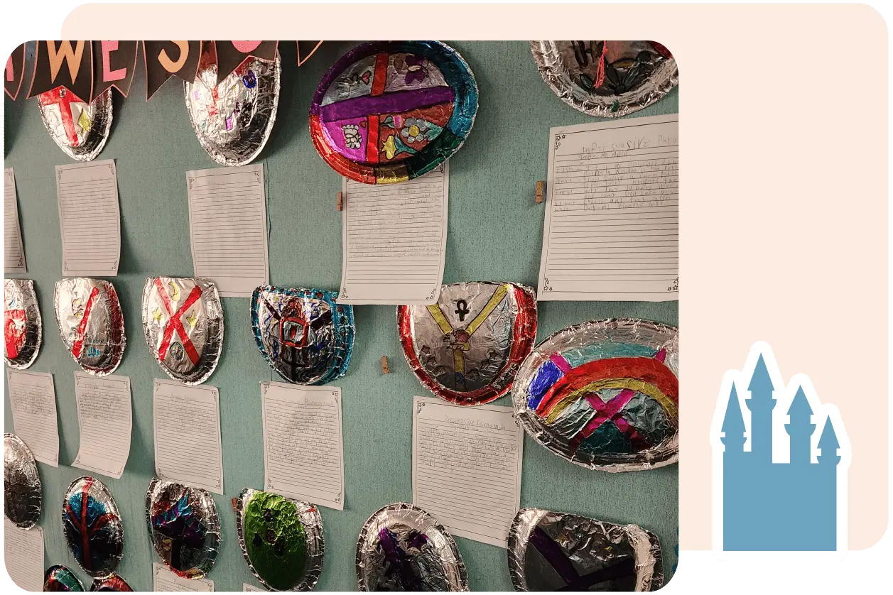 Decorative metallic shields and handwritten papers are displayed on a green wall. Some shields have colorful designs and symbols.