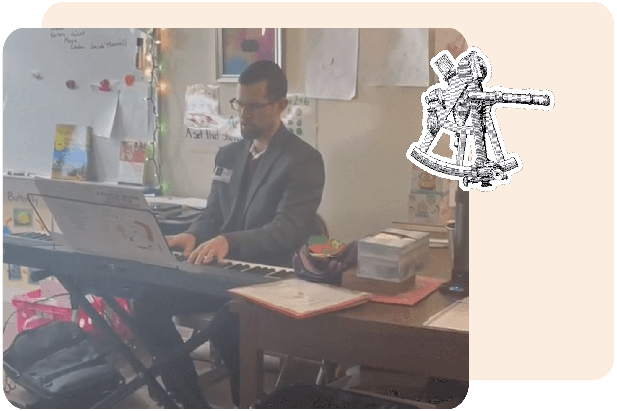 A man in a suit plays a digital piano in a room with wall art and decorations. A small telescope illustration is overlaid on the right side.