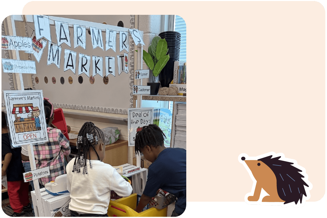 Children are playing at a pretend farmer's market, organizing items under a banner that reads "Farmer's Market." A hedgehog illustration is on the bottom right corner.