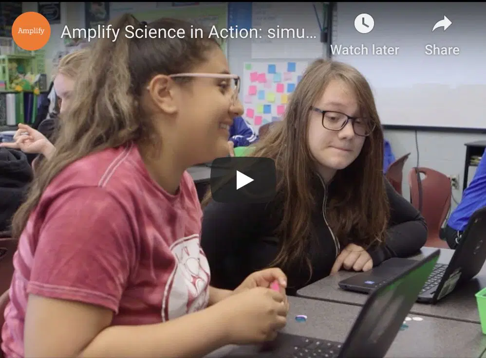 Students sitting at a table using laptops, engaging in a classroom activity.