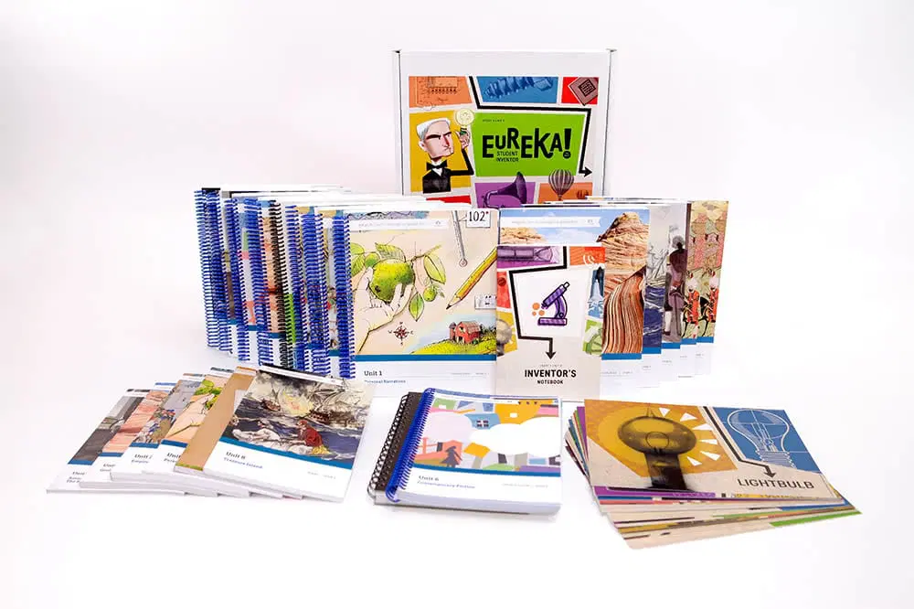 A collection of educational books, workbooks, and cards displayed in front of a box labeled “Eureka!” with various illustrations and diagrams on the covers.