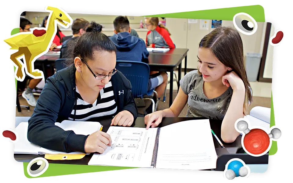 Two students sit at a classroom table working together on an assignment, with colorful illustrated science-themed graphics framing the image.