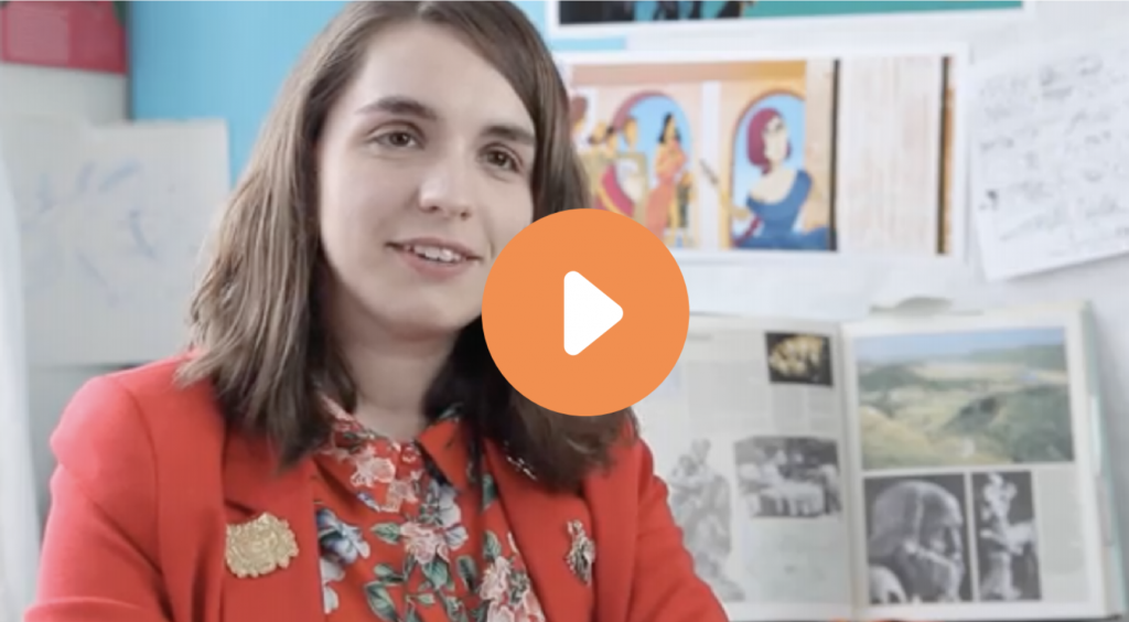 A woman in a red blazer and floral blouse speaking during an interview, with illustrations and photos in background. play button icon overlay.