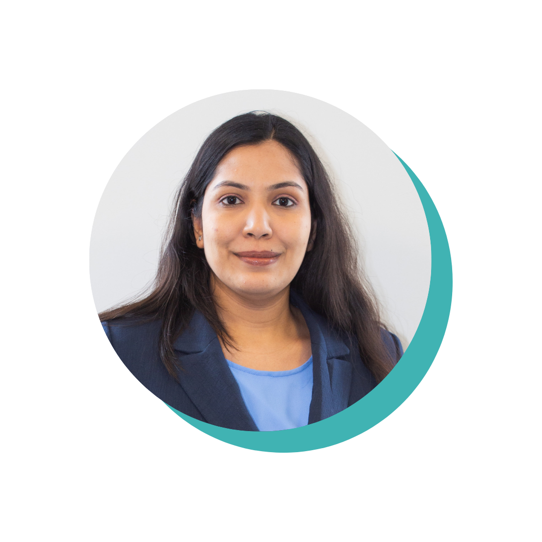 Businesswoman with long dark hair, wearing a dark blazer and blue blouse, poses in a professional portrait against a light background, representing math programs.