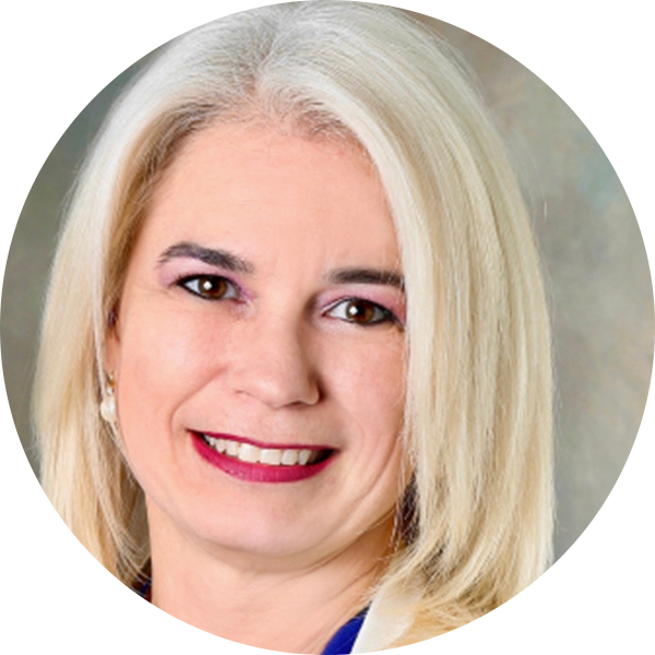 A woman with straight, shoulder-length blonde hair and light skin, wearing a blue top, smiles at the camera against a neutral background, reflecting the professional spirit of the Georgia Department of Education.